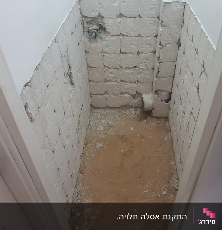 קיר לבנים חשוף עם צינור מים בולט